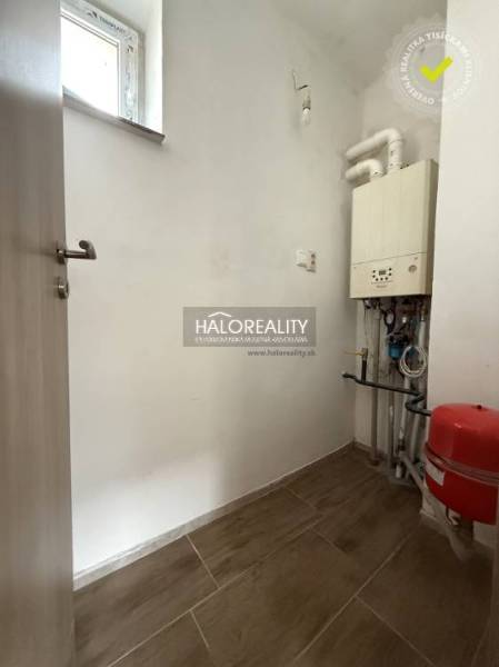 Technikraum in einem Einfamilienhaus mit einem Kessel und einem Boden mit Holzdekor.