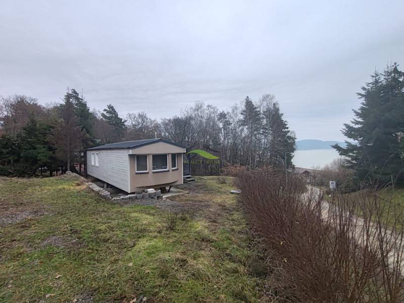 Ein Ferienhaus in der Hauptstraße in Nová Kelča mit Blick auf die Wasserfläche und den Wald.