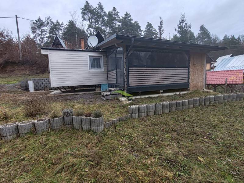 Ein Ferienhaus in Nová Kelča in der Hauptstraße, umgeben von Rasen und Bordsteinen.