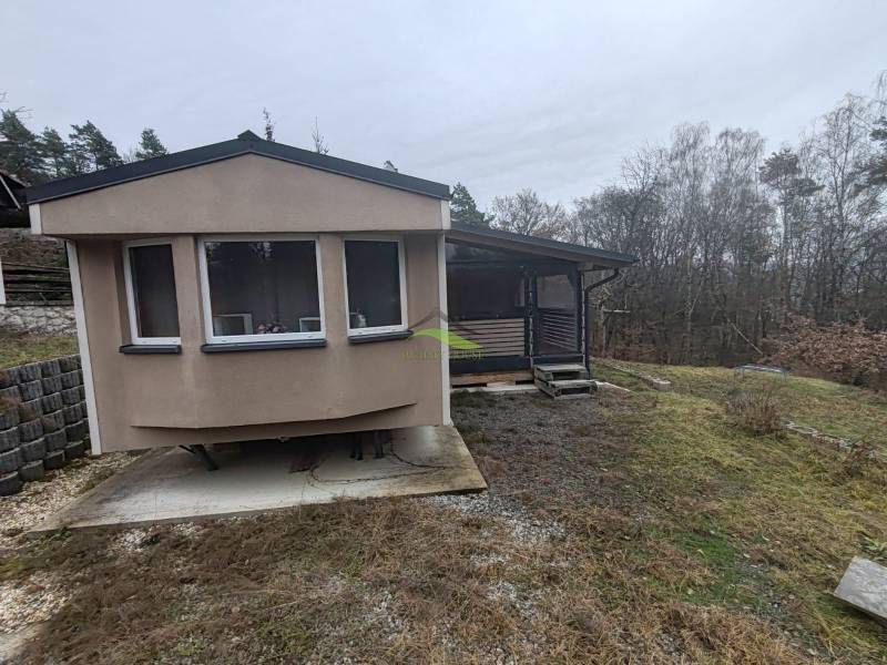 Das Haus an der Hauptstraße in Nová Kelča ist von Bäumen und leicht hügeligem Gelände umgeben.