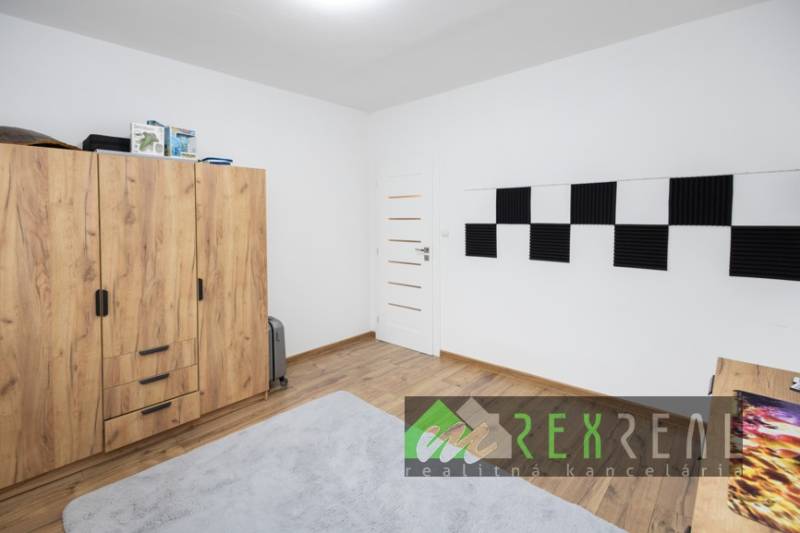 Kinderzimmer mit Holzboden und Schrank in einer 3-Zimmer-Wohnung.