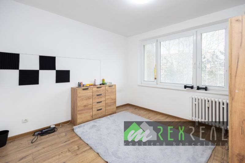 Ein Zimmer in einer 3-Zimmer-Wohnung mit einem Boden in Holzoptik und einem großen Fenster.