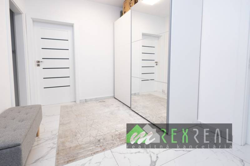 Flur mit Teppich, Spiegelschrank und Türen in einer 3-Zimmer-Wohnung.