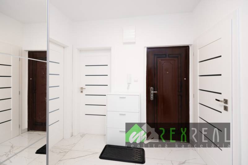 Der Flur mit weißen Türen und einem Spiegelschrank in einer 3-Zimmer-Wohnung.