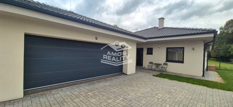 Ein Einfamilienhaus in Studienka mit zwei Stühlen und einem Tisch auf dem gepflasterten Hof.