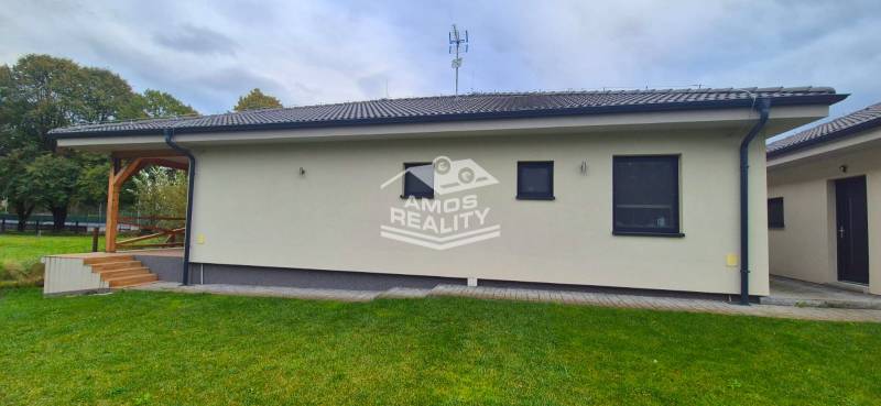 Ein Einfamilienhaus in Studienka mit Terrasse, grünem Rasen und moderner Fassade.