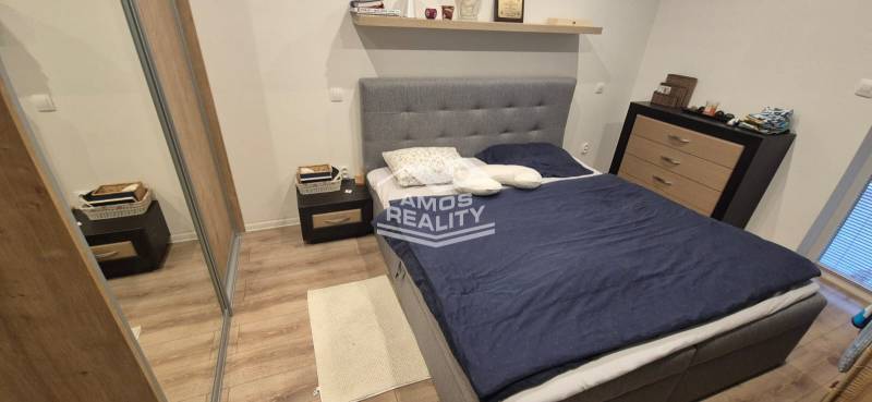 Schlafzimmer mit Holzboden, Bett und Stauraum in einem Einfamilienhaus.