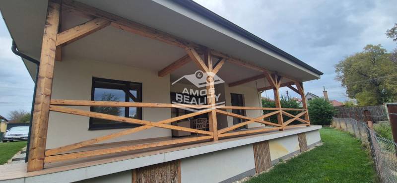 Das Einfamilienhaus in Studienka hat eine Terrasse mit einem Holzgeländer und einem angrenzenden Rasen.