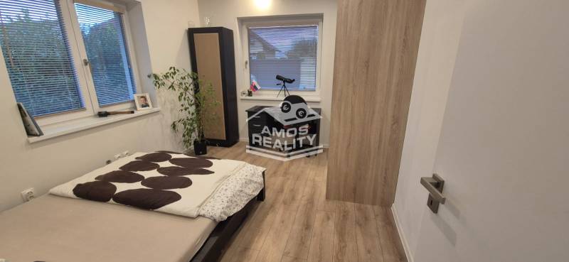 Schlafzimmer mit Bett, Tisch und Holzboden in einem Einfamilienhaus.