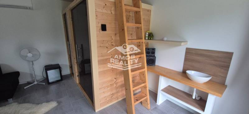 Innenraum eines Einfamilienhauses mit Holzsauna, Leiter und Stereoanlage.