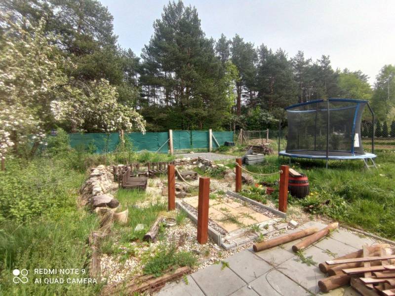 Der Garten bei der Hütte in Hliník nad Hronom mit einem Trampolin und einem Holzweg.
