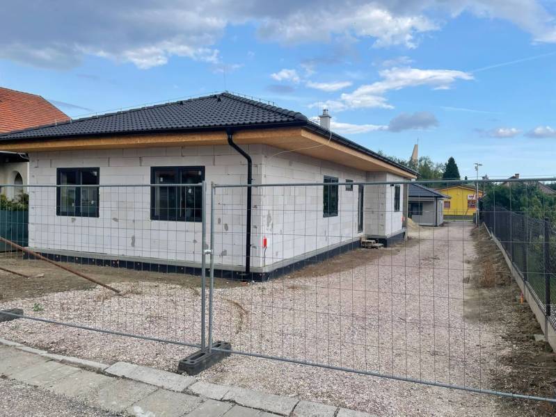 In Radava wird ein Einfamilienhaus mit einem schrägen Dach und einer weißen Fassade gebaut.