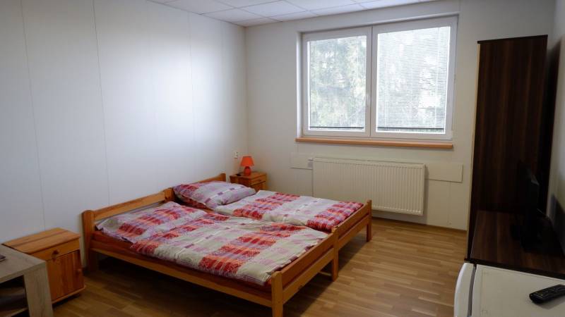 Ein Zimmer mit Doppelbett, Holzboden und modernen Möbeln in Hotels und Pensionen.