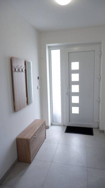 Eingangsbereich eines Einfamilienhauses mit Garderobe, Spiegel und Designtüren.