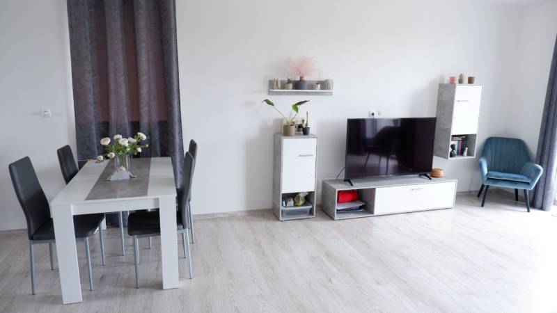 Innenraum eines Einfamilienhauses mit Esstisch, Fernseher und Holzboden.