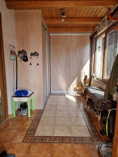 Flur mit Fliesen, Einbauschrank und Bank in einem Einfamilienhaus.