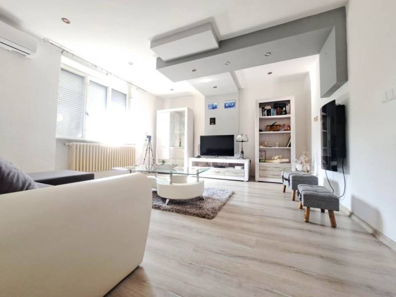 Wohnzimmer in einem Einfamilienhaus mit Holzboden und Sofa.