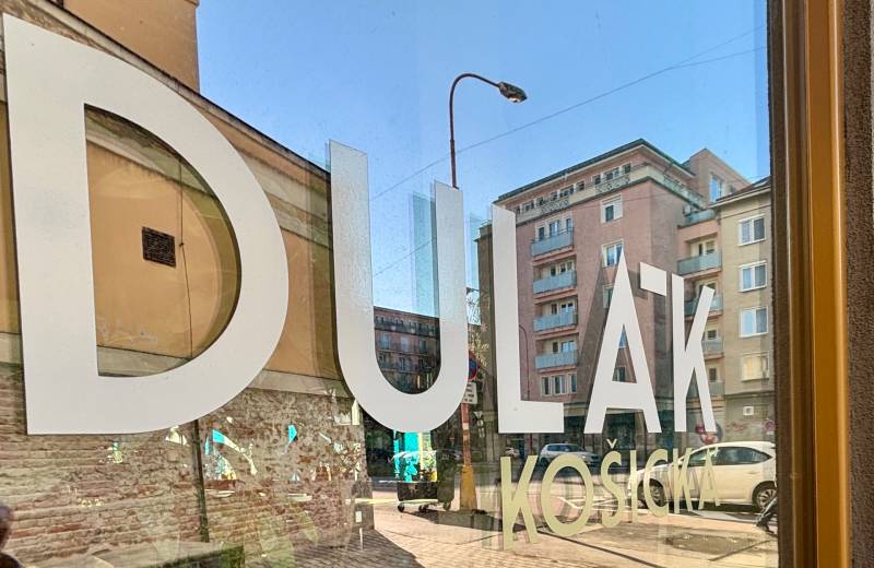 Die Reflexion im Glas zeigt die Fassaden der Gebäude auf dem Dulovo námestie, Bratislava - Nivy, 2-Zimmer-Wohnung.