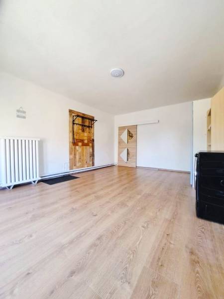 Innenraum eines Einfamilienhauses mit Holzboden und weißen Wänden.