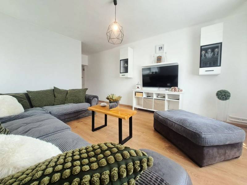 Wohnzimmer in einem Einfamilienhaus mit Holzboden und bequemer Sitzgarnitur.