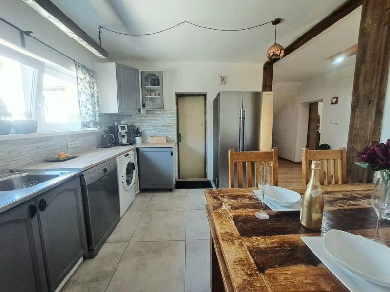 Eine Küche in einem Einfamilienhaus mit einem Holztisch und modernen Geräten.