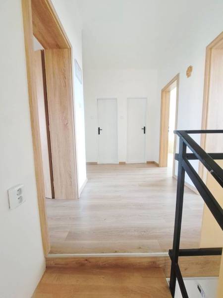 Innenraum eines Einfamilienhauses mit Holzboden und weißen Türen.