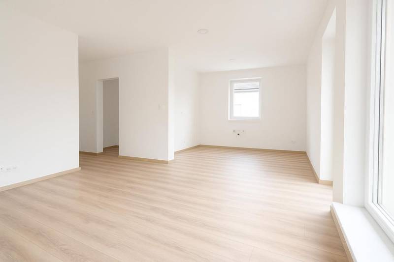 Weißes Interieur eines Einfamilienhauses mit Holzdekorboden und großem Fenster.