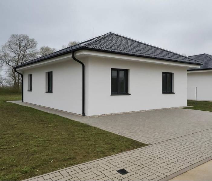 Einfamilienhaus in Cífer mit Schrägdach und gepflastertem Gehweg.