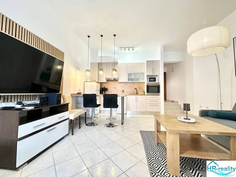 Ferienwohnung mit geräumigem Wohnzimmer, Küche und Fernseher.