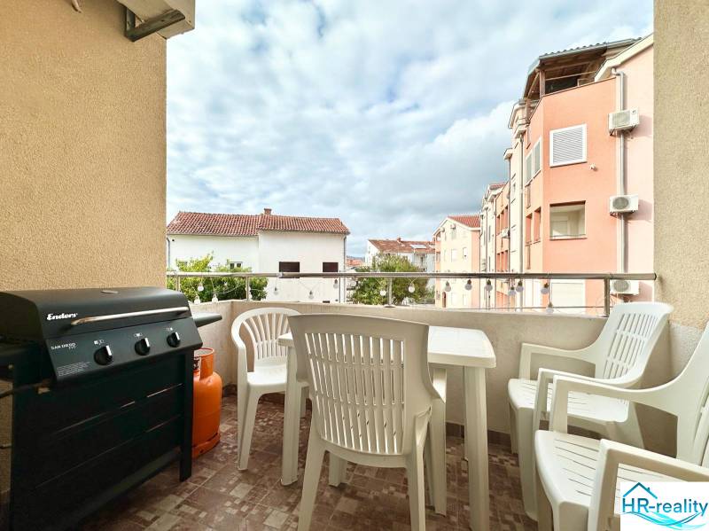 Balkon der Ferienwohnung in Okrug Gornji mit Grill und Plastikmöbeln.