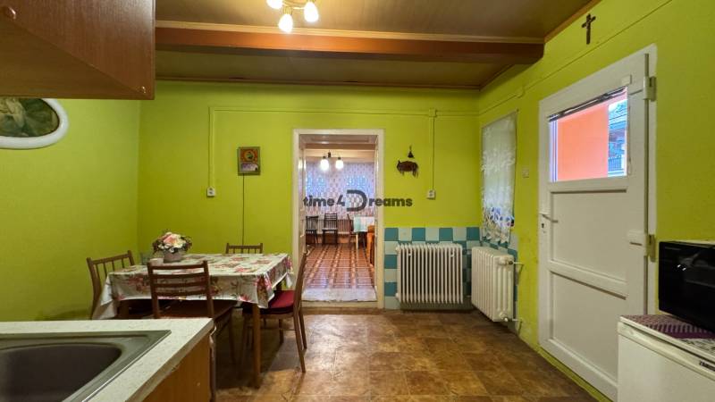 Küche im Einfamilienhaus mit Esszimmer, hellgrüne Wände, Blumenmuster auf dem Tisch.