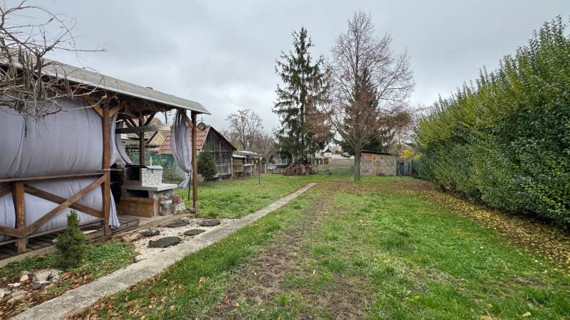 Der Garten beim Einfamilienhaus in Čechynce mit Pavillon und Gehweg, umgeben von Grün.