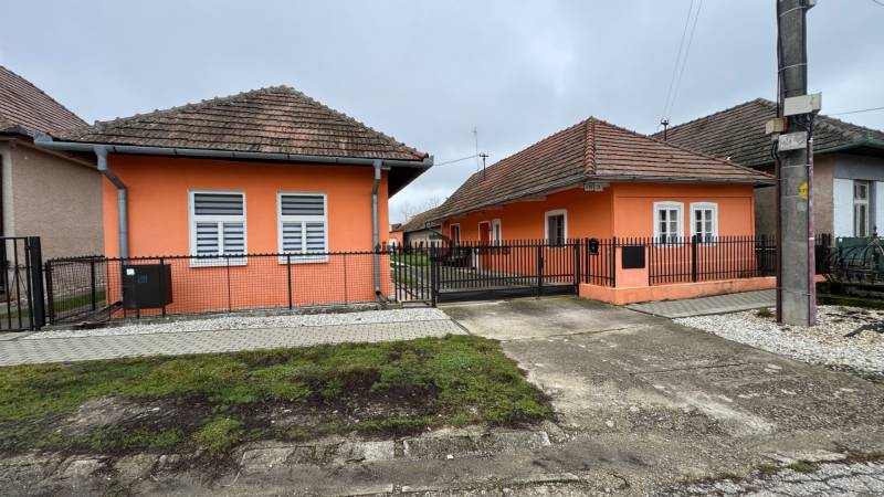 Ein Einfamilienhaus in Čechynce mit einer orangefarbenen Fassade und einem Ziegeldach.