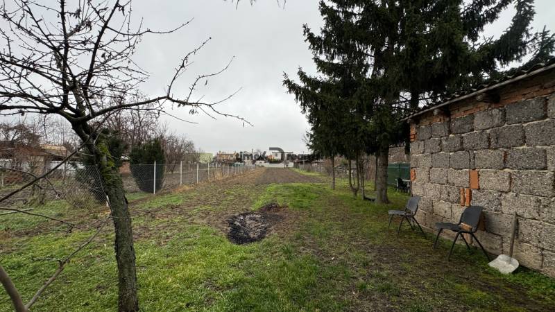 Garten bei einem Einfamilienhaus mit Zaun und Bäumen in Čechynce.