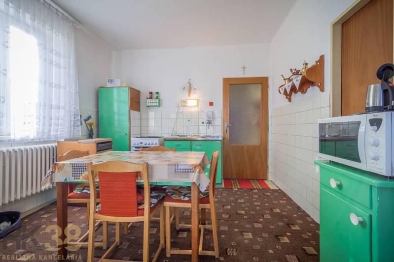 Küche in einem Einfamilienhaus mit Retro-Möbeln, Esstisch und Küchenausstattung.