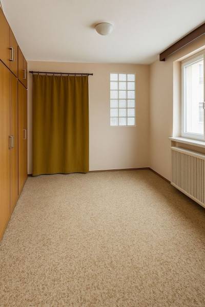 Ein Zimmer in einem Einfamilienhaus mit Teppichboden, Einbauschrank und Vorhang.