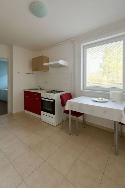 Küche mit rotem Schrank, Tisch und zwei Stühlen in einem Einfamilienhaus.