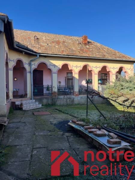Ein Einfamilienhaus in Tomášovce mit Terrasse und verzierter Fassade.