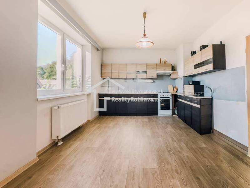 Küche in einem Einfamilienhaus mit Holzboden und großem Fenster.