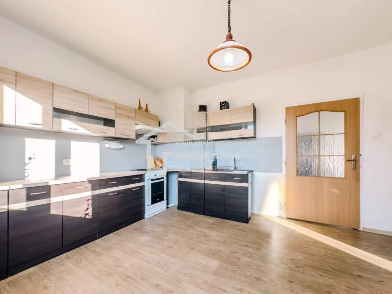 Eine Küche in einem Einfamilienhaus mit einem Holzboden und modernen Küchenzeilen.