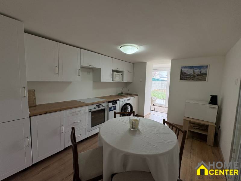 Küche in einer Einzimmerwohnung mit Holzboden und Esstisch.