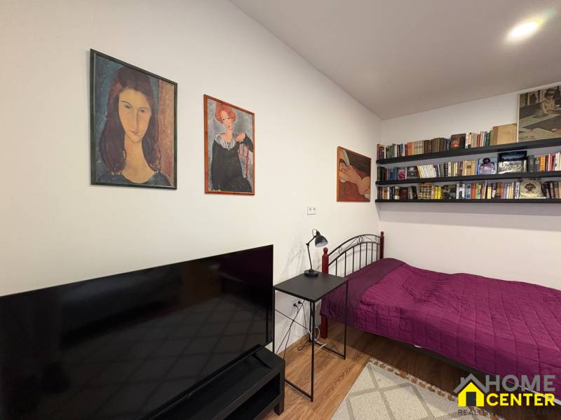 Einzimmerwohnung mit Bett, Bücherregalen und Fernseher, Boden mit Holzdekor.