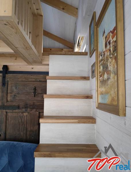 Holztreppe im Einfamilienhaus, Wände mit hängenden Bildern.