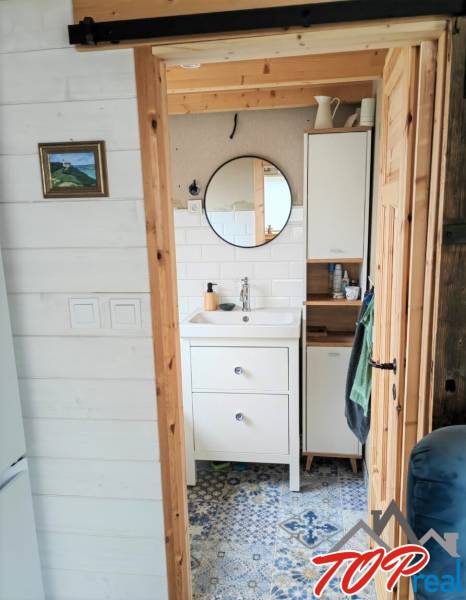 Badezimmer in einem Einfamilienhaus mit rundem Spiegel und gemusterten Fliesen.