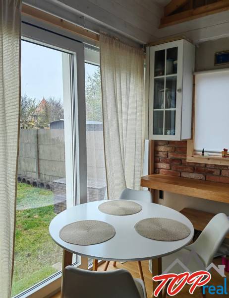 Essbereich in einem Einfamilienhaus mit Holzboden, Ziegelwand und großen Fenstern.