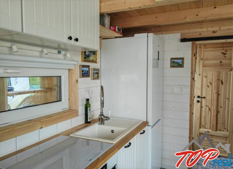 Eine Küche in einem Einfamilienhaus mit weißen Möbeln und Holzelementen.