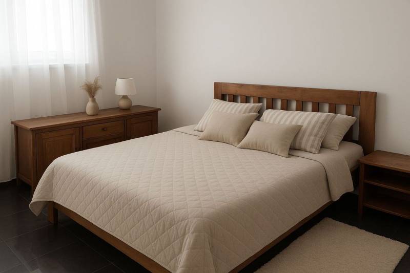 Schlafzimmer mit Holzmöbeln, Bett und dekorativen Kissen, gedämpfte Farben.