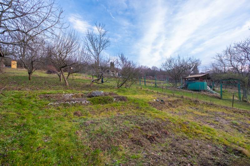 Ein Garten mit Obstbäumen bei einer Hütte in der Nähe von Prešov, umgeben von Natur.