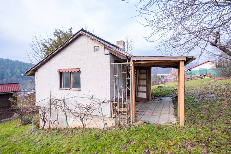Eine Hütte in Prešov mit Holzkonstruktion und einem Weinberg auf einem grasbewachsenen Hügel.