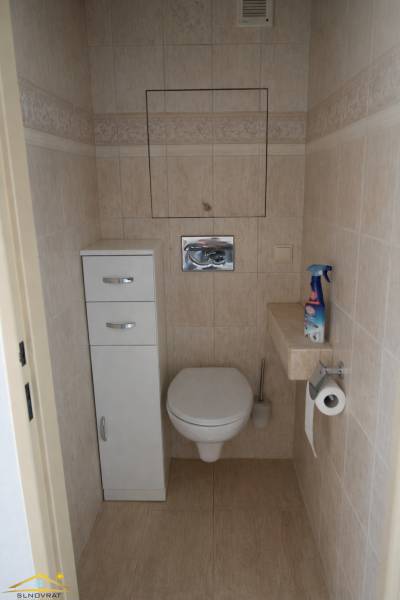 Toilette in hellen Fliesen in einer 3-Zimmer-Wohnung mit Stauraum.
